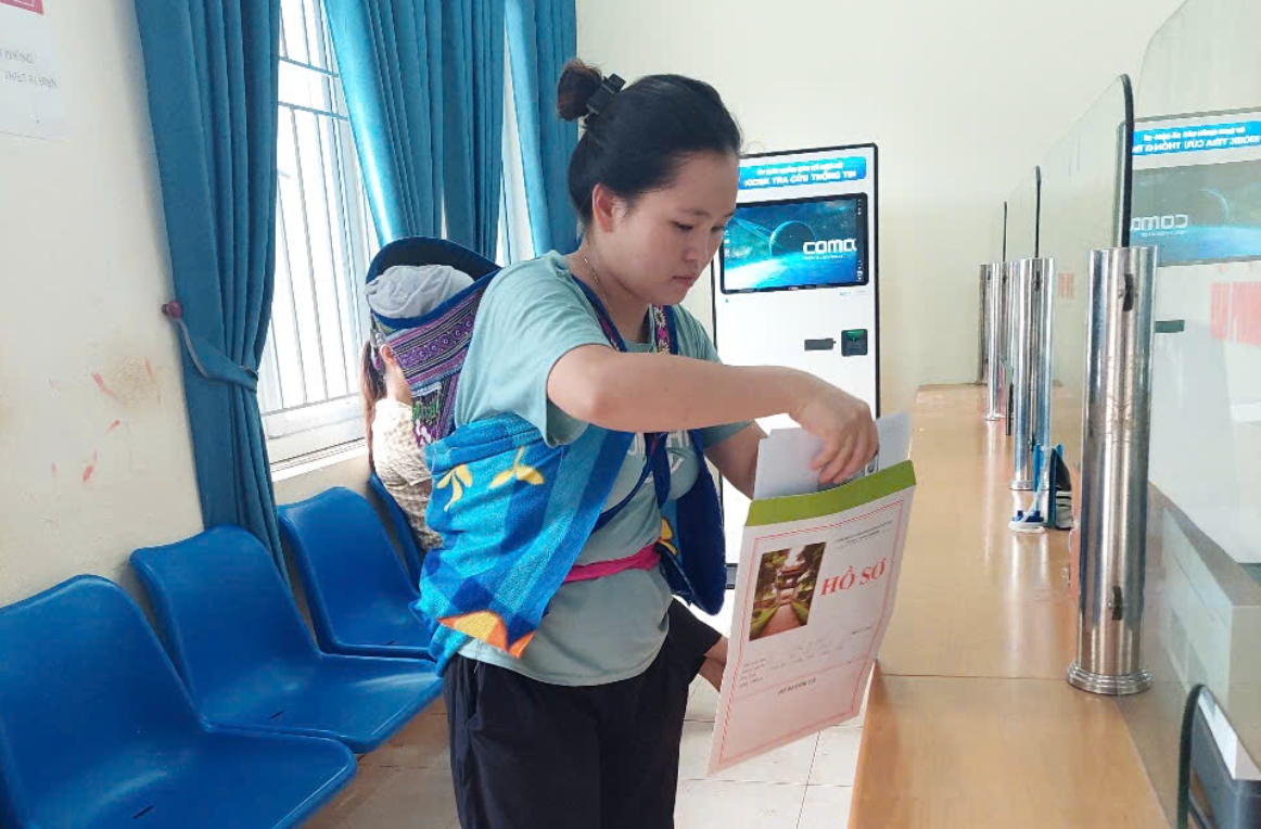 Chị Di đưa con đến trung tâm xã Nậm Kè mới để làm thủ tục khai sinh.