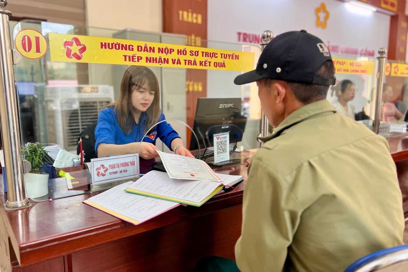 Chị Thảo hướng dẫn người dân làm thủ tục khai sinh tại Trung tâm hành chính công xã Chiềng Sinh.