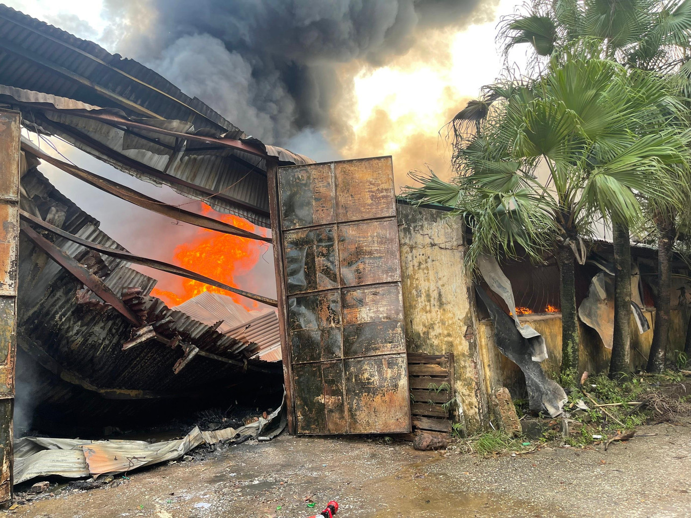 Phần mái tôn bị lửa làm biến dạng. Phần mái tôn bị lửa làm biến dạng.