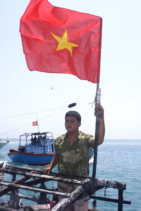 Bùi Văn Phái bên lá cờ tổ quốc mới