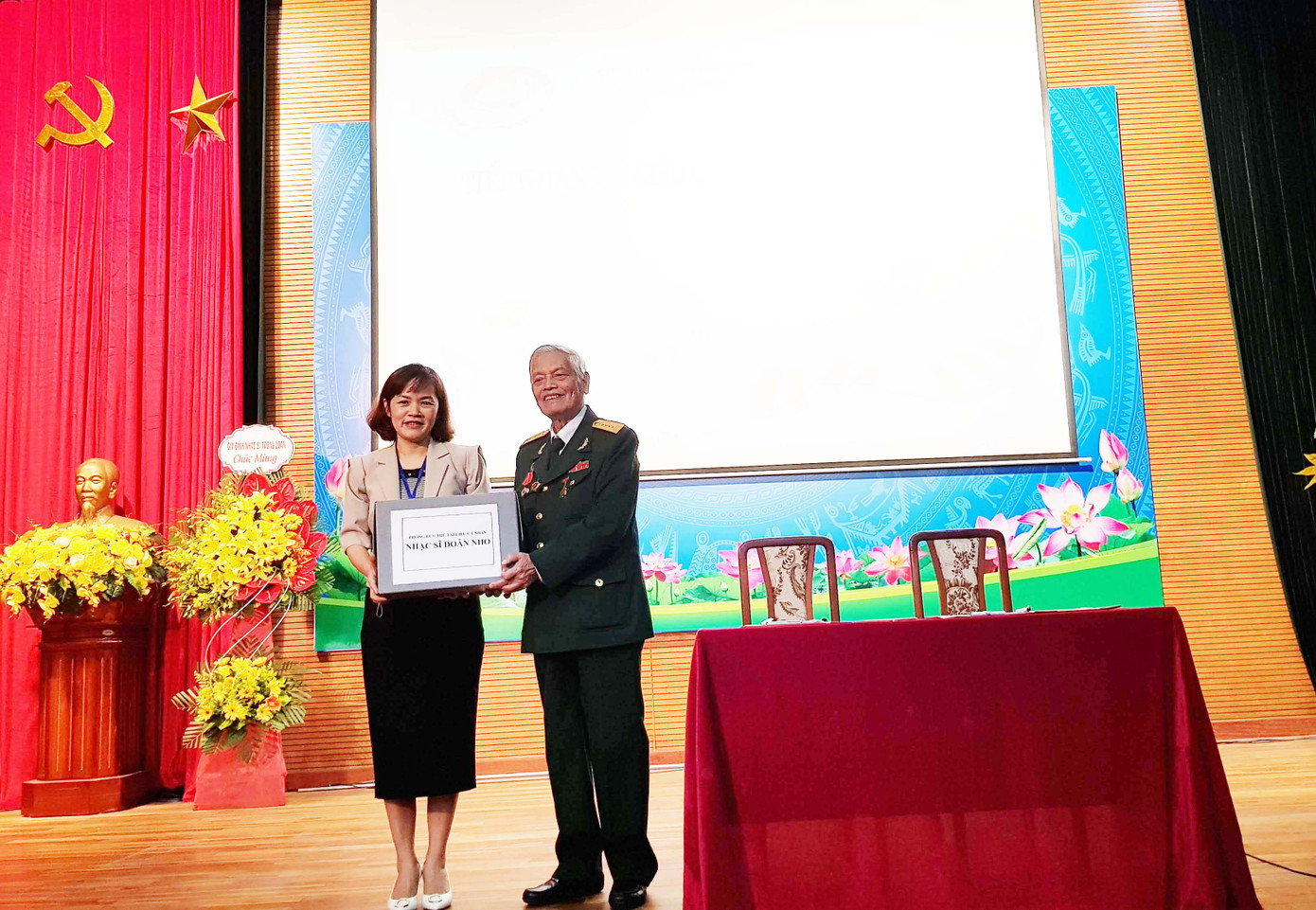 Giám đốc Trung tâm Lưu trữ Quốc gia III Trần Việt Hoa tiếp nhận những tài liệu của nhạc sĩ Doãn Nho. Ảnh: Kiến Nghĩa.