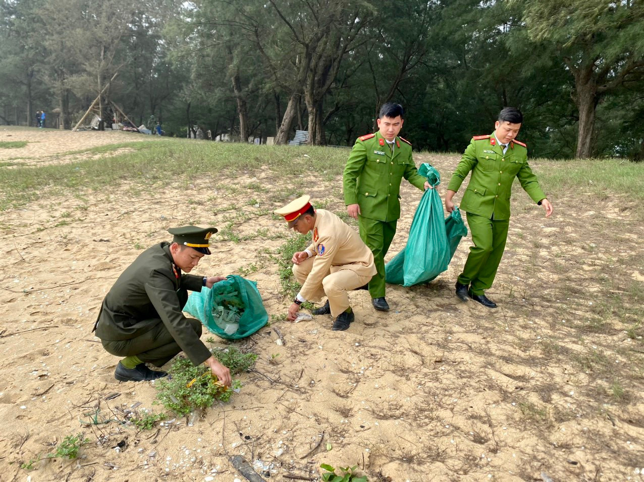 Các đoàn viên thanh niên Đoàn Công an huyện Quảng Trạch nhặt và thu gom rác thải trên bãi biển