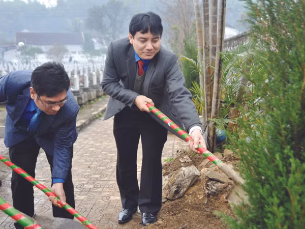 Bí thư thứ nhất T.Ư Đoàn Nguyễn Đắc Vinh và Chủ tịch Hội LHTN Việt Nam Nguyễn Phước Lộc trồng cây tại Nghĩa trang liệt sĩ Việt - Lào ngày 15-1. Ảnh: L.X.S