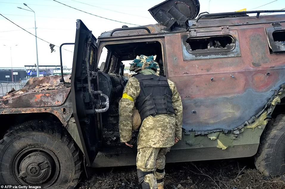Một tay súng thuộc Lực lượng Phòng thủ Lãnh thổ Ukraine kiểm tra xe cơ động bộ binh Nga GAZ Tigr bị phá hủy sau cuộc chiến ở Kharkiv. Ảnh: Getty Images.