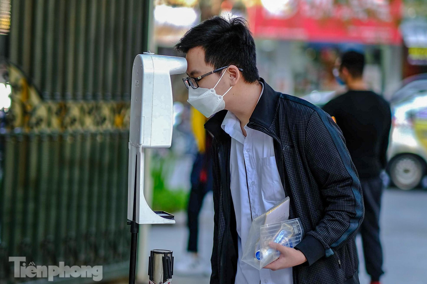 Học sinh và phụ huynh được khai báo y tế, kiểm tra thân nhiệt tự động, sát khuẩn tay trước khi vào địa điểm tiêm chủng.