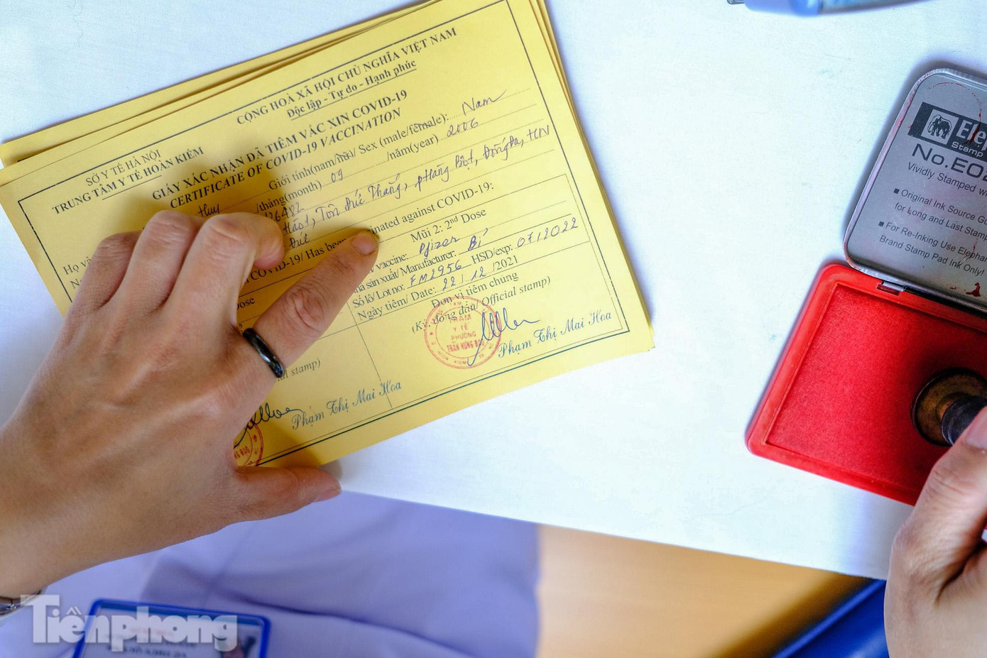 Các nhân viên y tế đóng dấu chứng nhận mũi tiêm số 2.