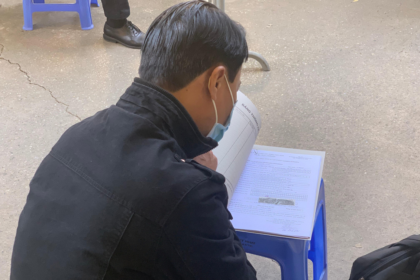 Nhiều người vội vã kiểm tra hồ sơ trước khi vào đăng ký.