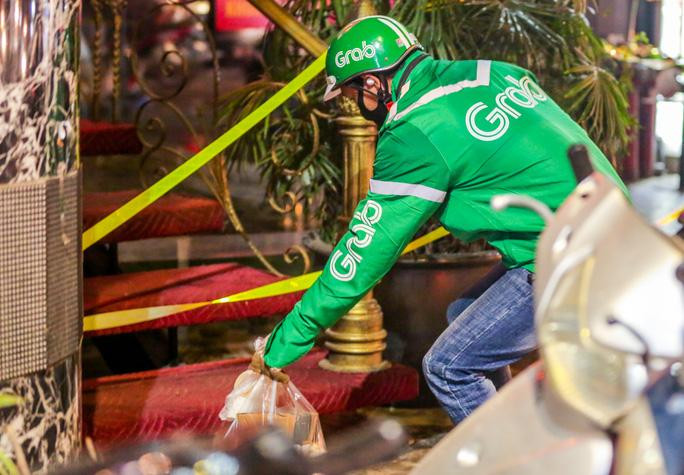 Một tài xế xe công nghệ tiếp tế nhu yếu phẩm cho người bên trong khu vực cách ly