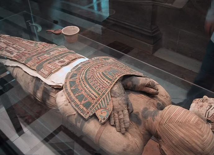 Xác ướp nằm trên giường được bao quanh bởi hình ảnh các nữ thần Isis và Nephthys, cũng như bốn người con trai của Horus, vị thần của vương quyền.