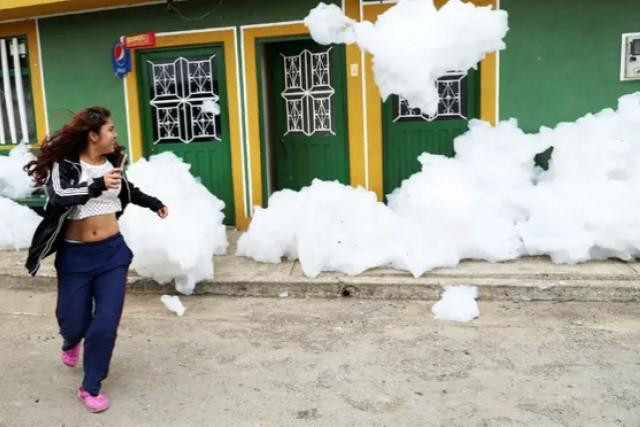 Một người phụ nữ chạy khỏi đám bọt độc hại "bao vây" ngôi nhà của cô ấy ở Mosquera. Các nhà chức trách đã cảnh báo người dân địa phương không nên đến quá gần lớp bọt độc hại. Ảnh: Luisa Gonzále /Reuters Một người phụ nữ chạy khỏi đám bọt độc hại "bao vây" ngôi nhà của cô ấy ở Mosquera. Các nhà chức trách đã cảnh báo người dân địa phương không nên đến quá gần lớp bọt độc hại. Ảnh: Luisa Gonzále /Reuters