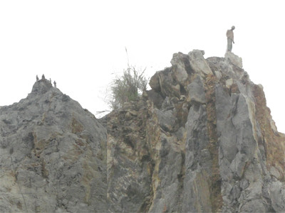 Công nhân mỏ đá cheo leo trên đỉnh núi cắt ngọn, hạ độ cao