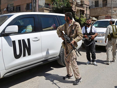 Các binh sĩ Quân đội Syria Tự do hôm 28/8 hộ tống đoàn xe chở các thanh sát viên LHQ điều tra cáo buộc tấn công vũ khí hóa học ở Damascus. Ảnh: Bassam Khabieh