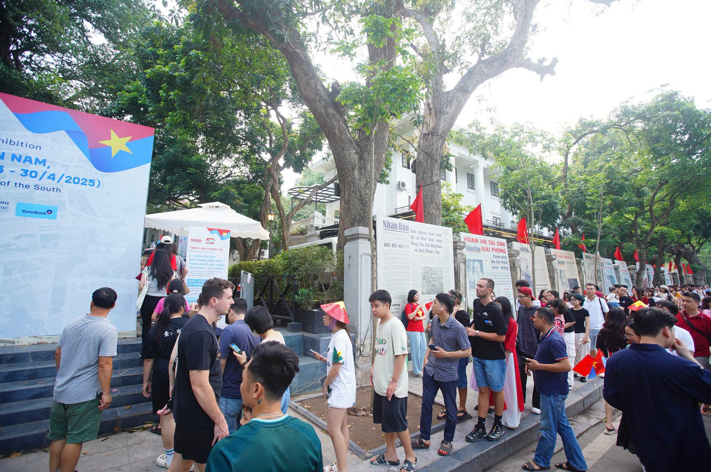 Trên vỉa hè khu vực Bờ Hồ người dân và du khách tản bộ, chụp ảnh kỉ niệm.