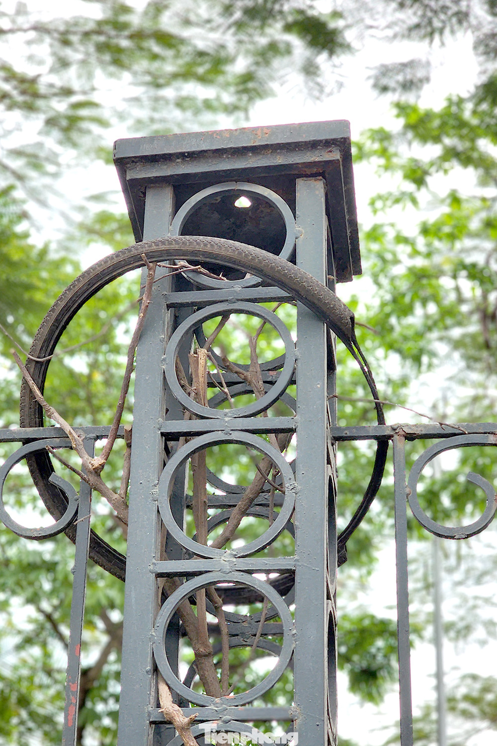 Phế liệu vứt bừa bãi trên trụ rào sắt.