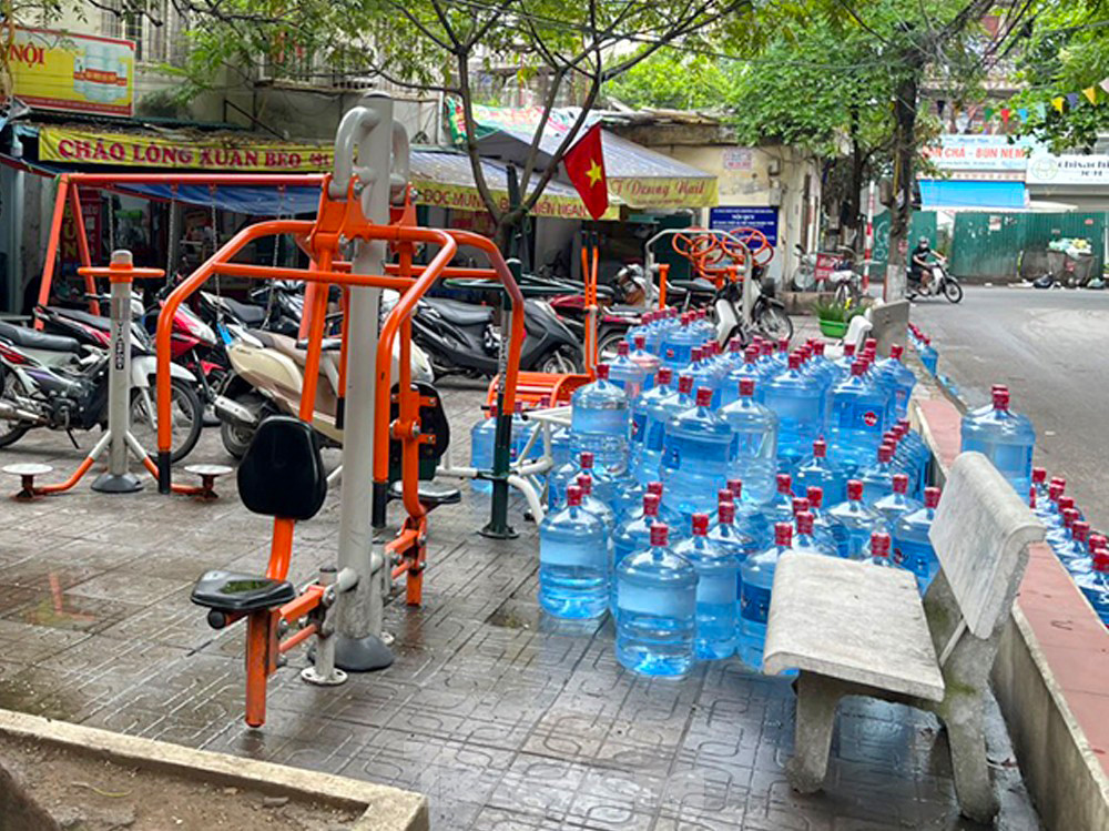 Cửa hàng kinh doanh nước đóng chai bên đường dù thuộc khu nhà A , vẫn ngang nhiên 'vươn' qua mặt đường để lấn chiếm sân chơi làm bãi tập kết bất kể ngày nắng mưa.