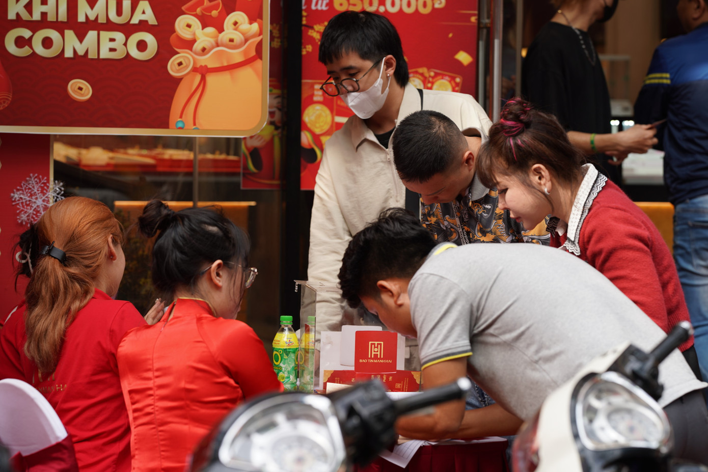 Ở một góc phố khác, khá đông người dân ngồi quan sát và liên tục xem bảng giá với tâm lý chờ đến cuối ngày giá vàng có thể giảm hơn rồi mới quyết định mua.