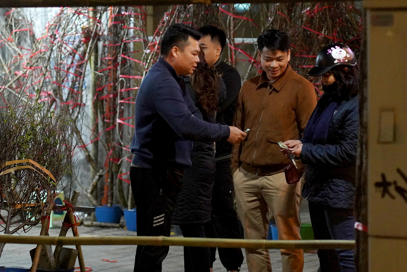 Một đoàn khách đi tỉnh dừng lại mua hoa đào.