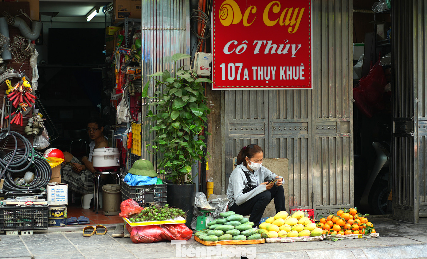 Sạp hoa quả lấn chiếm hết mặt vỉa hè vốn dĩ không rộng lắm trên đoạn đường này.