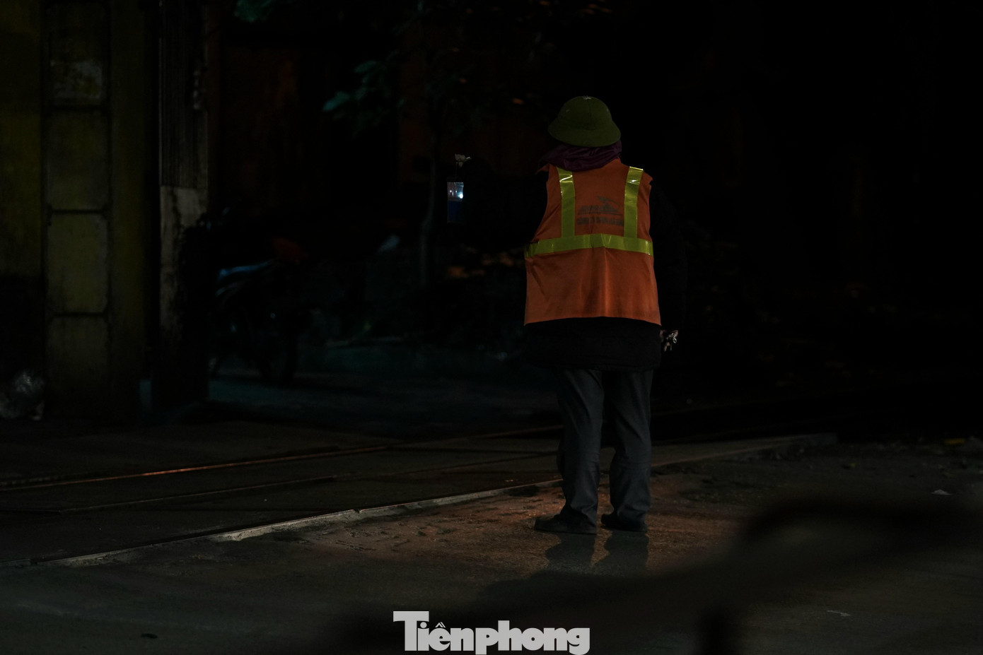 Người trực chốt ga đường tàu đang dẫn đèn hiệu cho chuyến tàu đêm.