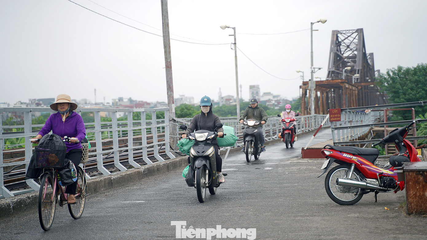 Người dân đi lại trên cầu Long Biên trong mưa nhỏ và gió thổi mạnh. Người dân đi lại trên cầu Long Biên trong mưa nhỏ và gió thổi mạnh.