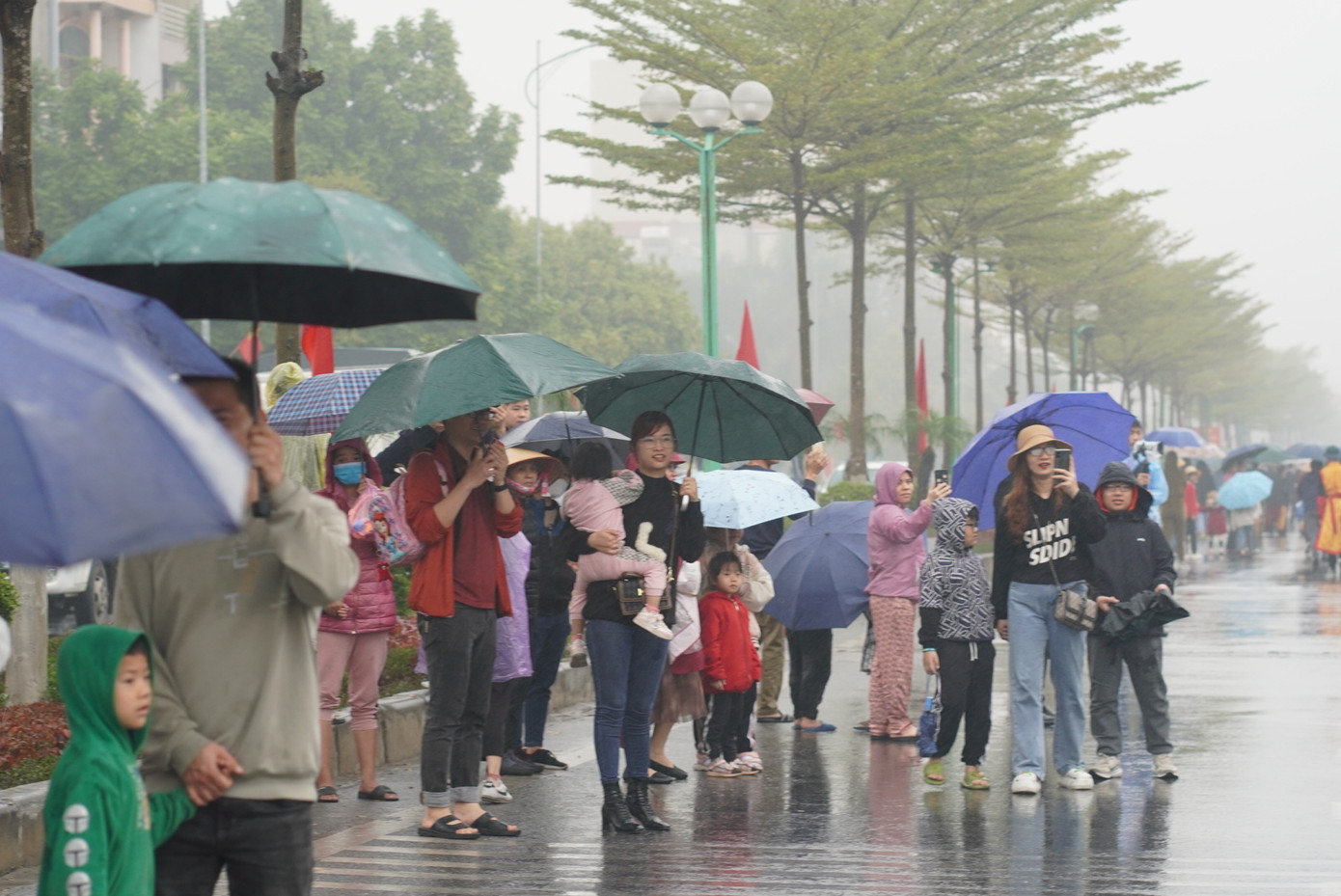 Người dân đội mưa đi theo đoàn rước lễ.