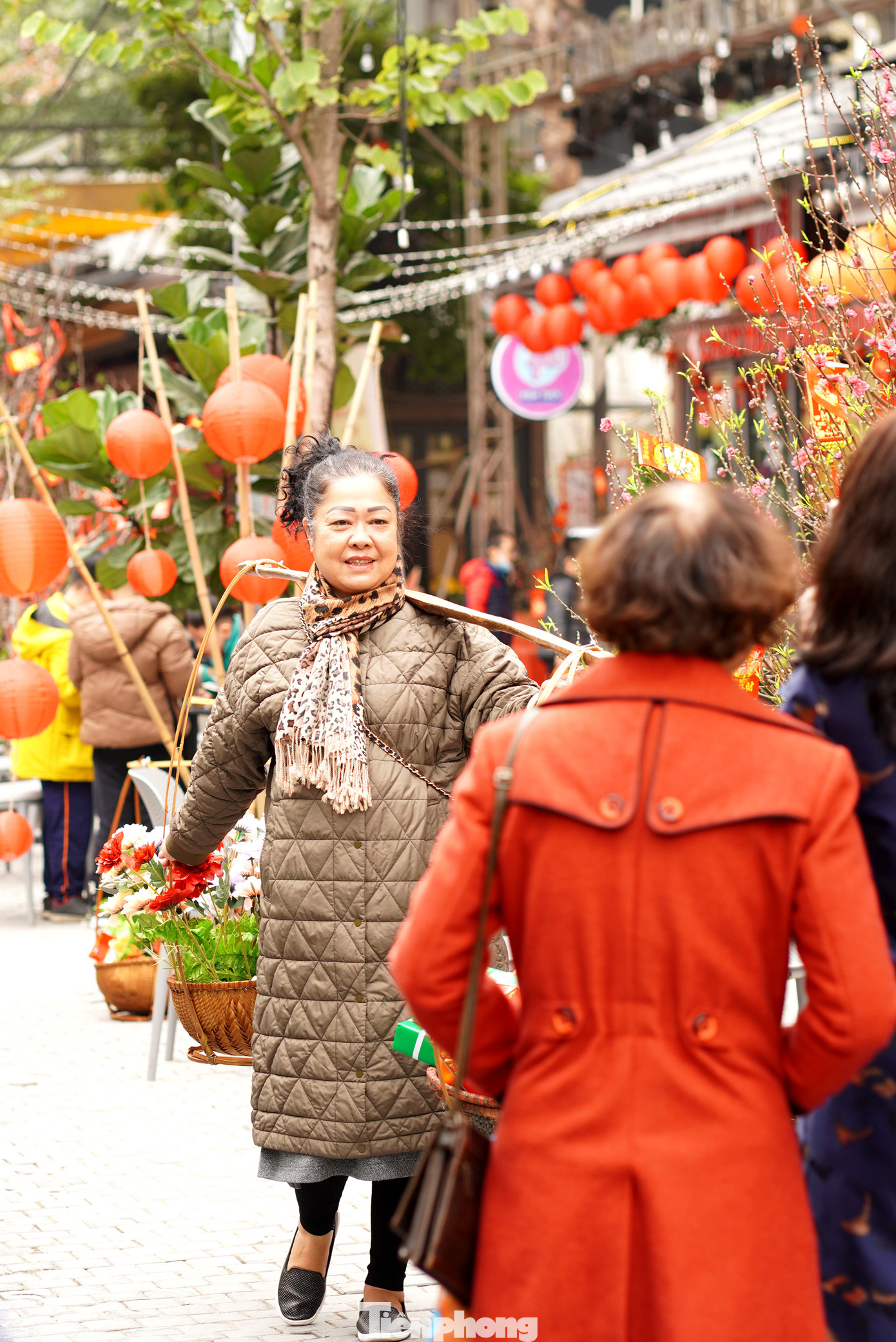 Các du khách vui vẻ chụp ảnh check in với gánh hàng hoa truyền thống.