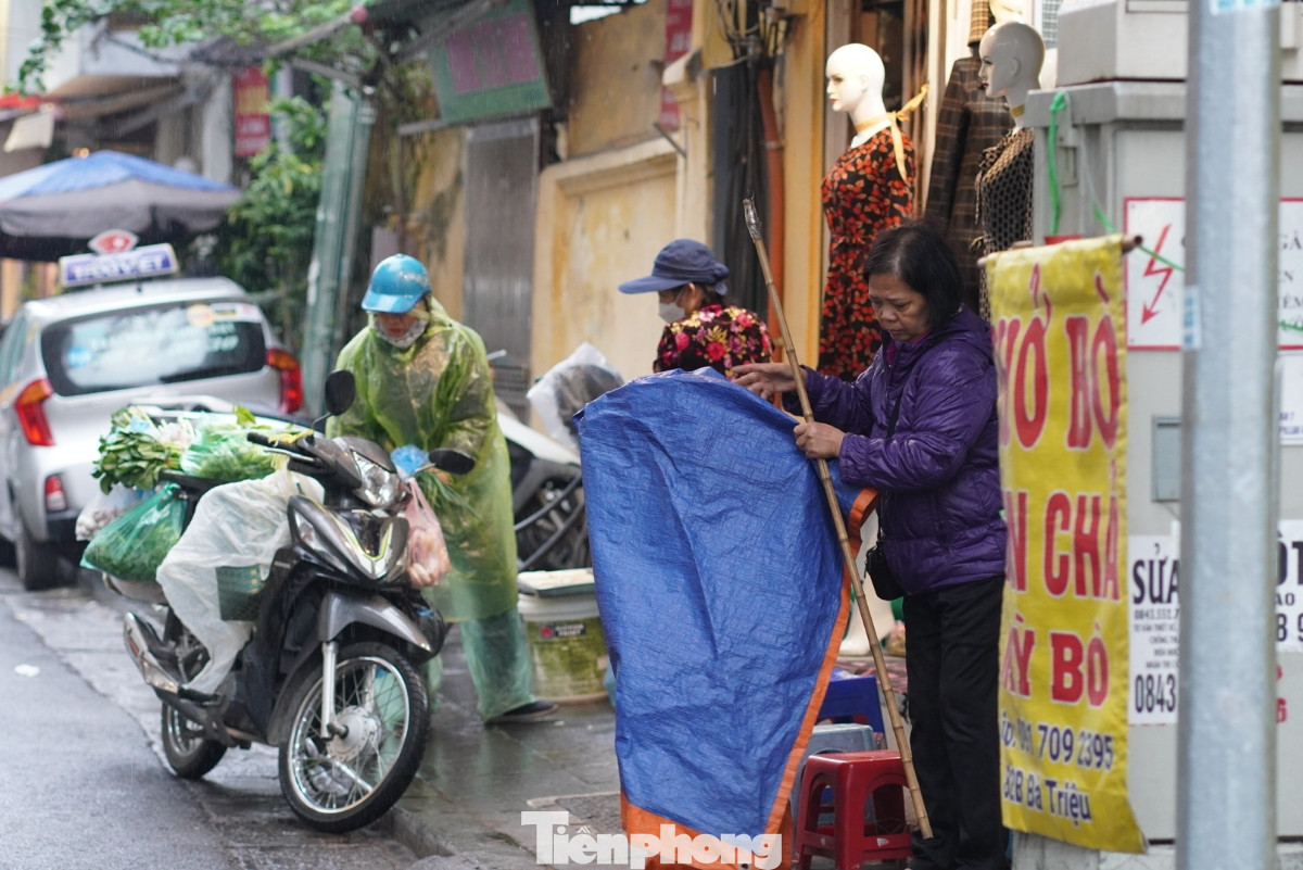 Người dân bắt đầu phủ áo mưa, che bạt chắn mưa chắn gió.