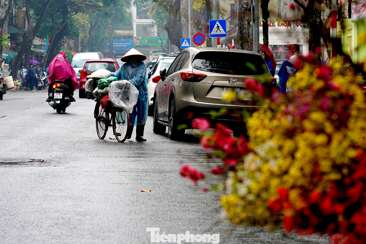 Đội nón, mặc chiếc áo mưa mỏng, người lao động lại tiếp tục rong ruổi khắp ngõ ngách đường phố để mưu sinh.