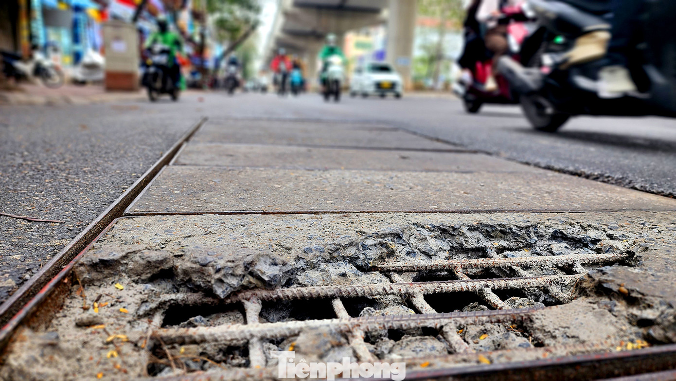 Một nắp hố kĩ thuật tróc mất phần xi măng, còn trơ lại cốt thép.