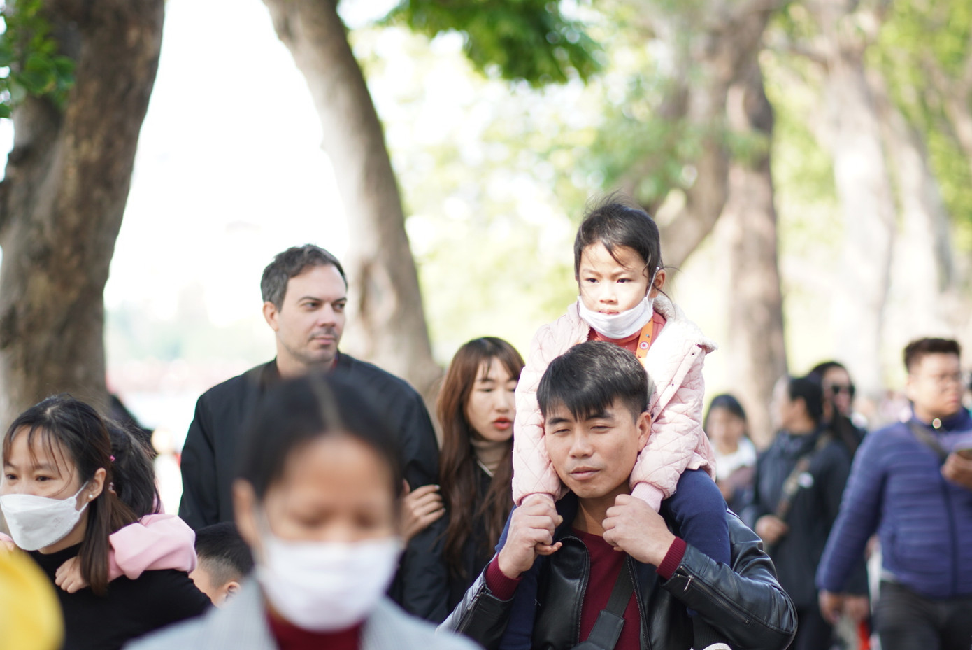 Một em bé du xuân trên vai người cha của mình.