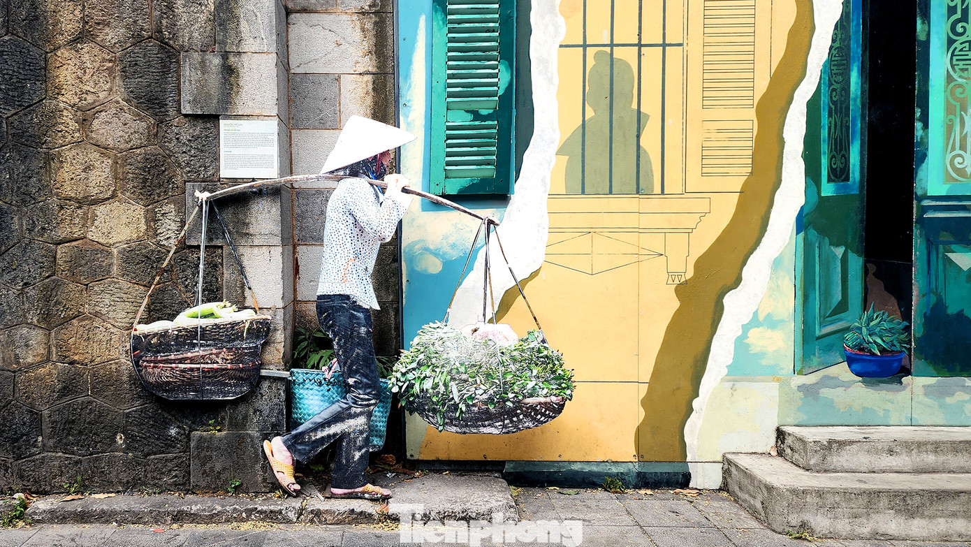 Gánh hàng rong đã được họa sĩ đi màu lại, thay thế lớp nền xuống cấp lẫn bong tróc trước đây.