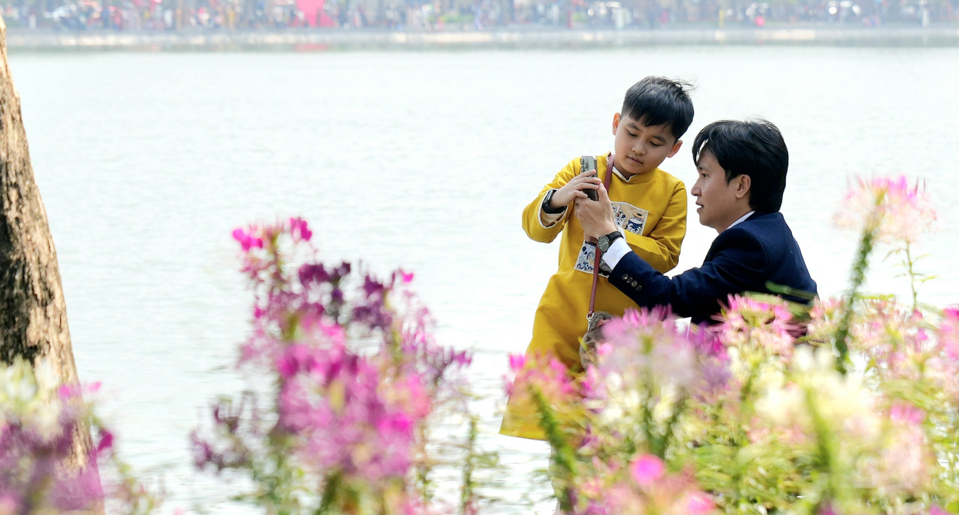 Các em nhỏ xúng xính diện đồ đón xuân, dạo chơi cùng gia đình, làm không khí phố phường càng thêm thanh bình, dễ chịu.