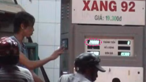 Trong khi một nhân viên đổ xăng thì một nhân viên khác nhanh tay bấm số gian lận từ 17.577 đồng (ảnh trên) thành 20.000 đồng (ảnh dưới) (ảnh chụp từ clip quay tại cửa hàng xăng dầu 133 Hùng Vương, P.6, Q.6 tối 10-3-2011). Ảnh: Sơn Lâm. Trong khi một nhân viên đổ xăng thì một nhân viên khác nhanh tay bấm số gian lận từ 17.577 đồng (ảnh trên) thành 20.000 đồng (ảnh dưới) (ảnh chụp từ clip quay tại cửa hàng xăng dầu 133 Hùng Vương, P.6, Q.6 tối 10-3-2011) - Ảnh: Sơn Lâm