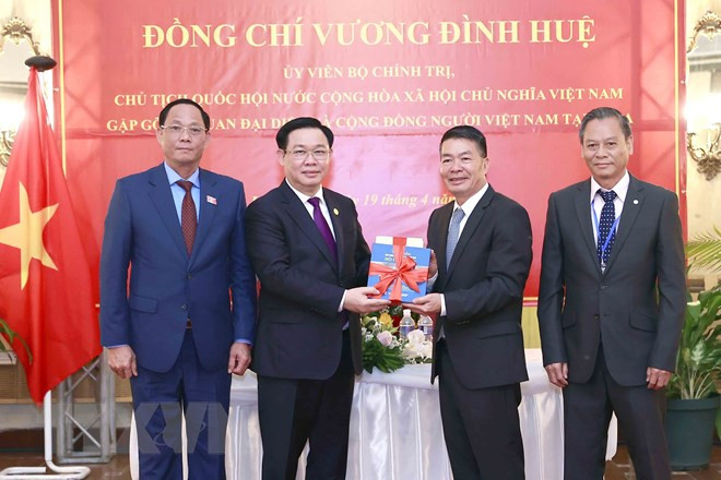 Chủ tịch Quốc hội Vương Đình Huệ trao tập sách tượng trưng (tủ sách về Bác Hồ) cho Đại sứ và đại diện cộng đồng. (Ảnh: Doãn Tấn/TTXVN)