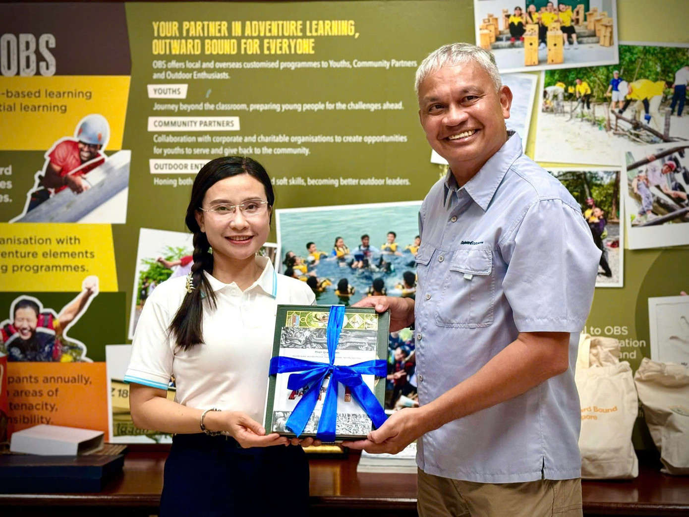 Ông Nicholas Conceicao tặng quà chị Nguyễn Phạm Duy Trang dịp đến thăm Trung tâm Outward Bound Singapore. Ảnh: BTC