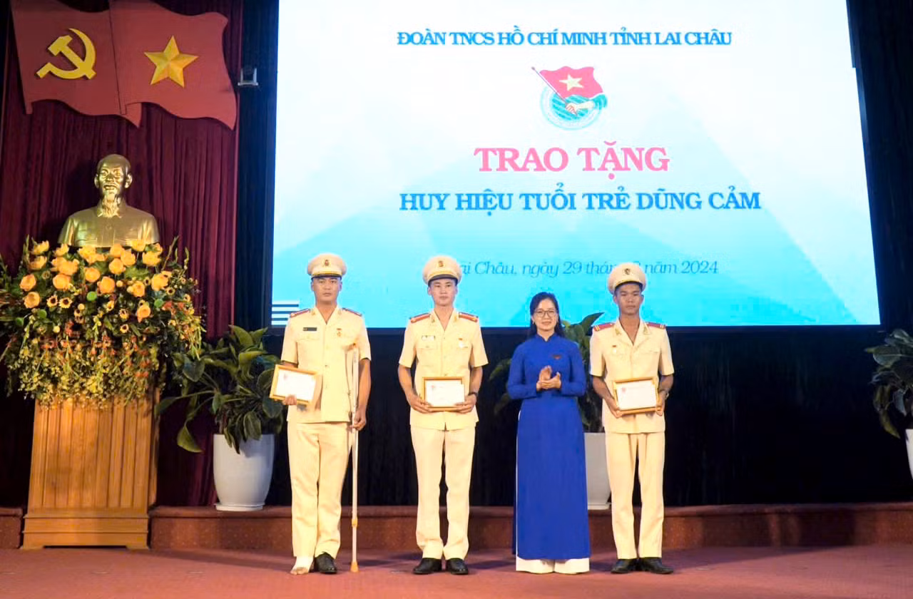 Chị Vừ Thị Mai Dinh trao Huy hiệu "Tuổi trẻ dũng cảm" cho 3 đoàn viên cứu người đuối nước. Ảnh: TĐLC