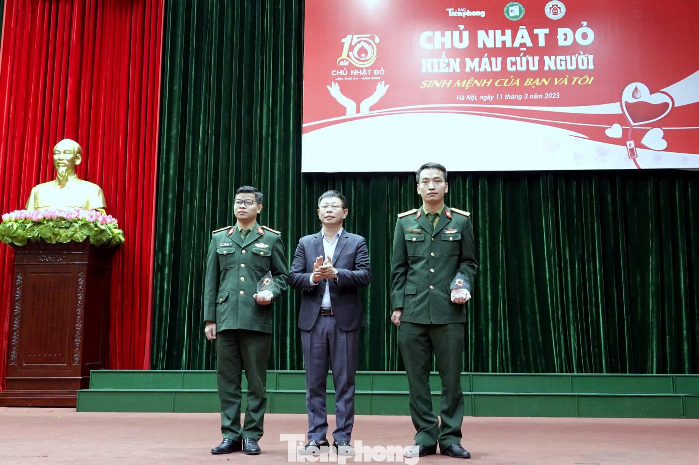 Nhà báo Phùng Công Sưởng - Phó Tổng biên tập báo Tiền Phong trao biểu trưng Chủ nhật Đỏ tặng cán bộ Học viện KTQS.