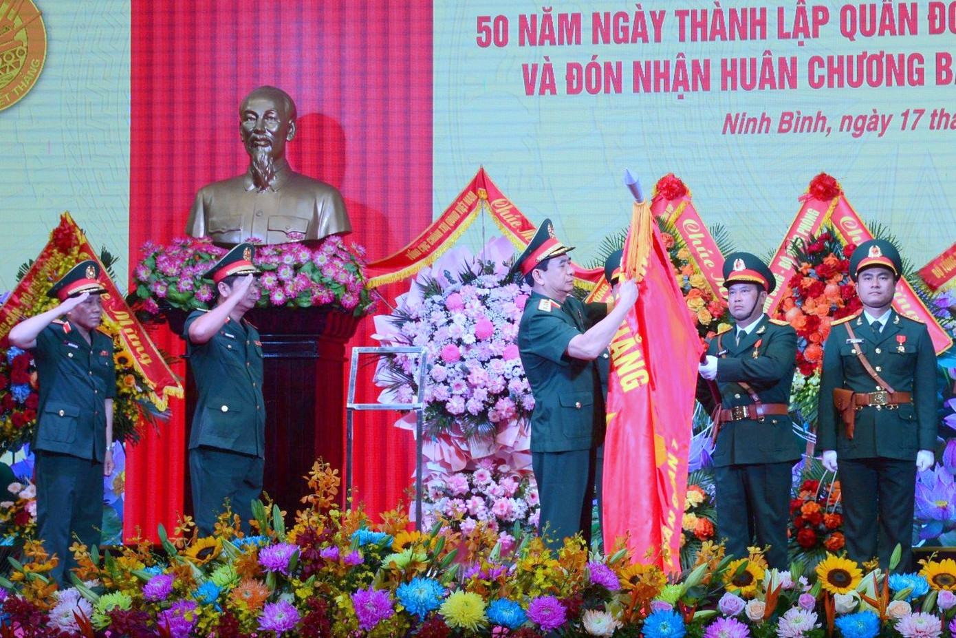 Đại tướng Phan Văn Giang gắn Huân chương Bảo vệ Tổ quốc hạng Nhất lên Quân kỳ Quyết thắng của Quân đoàn 1.