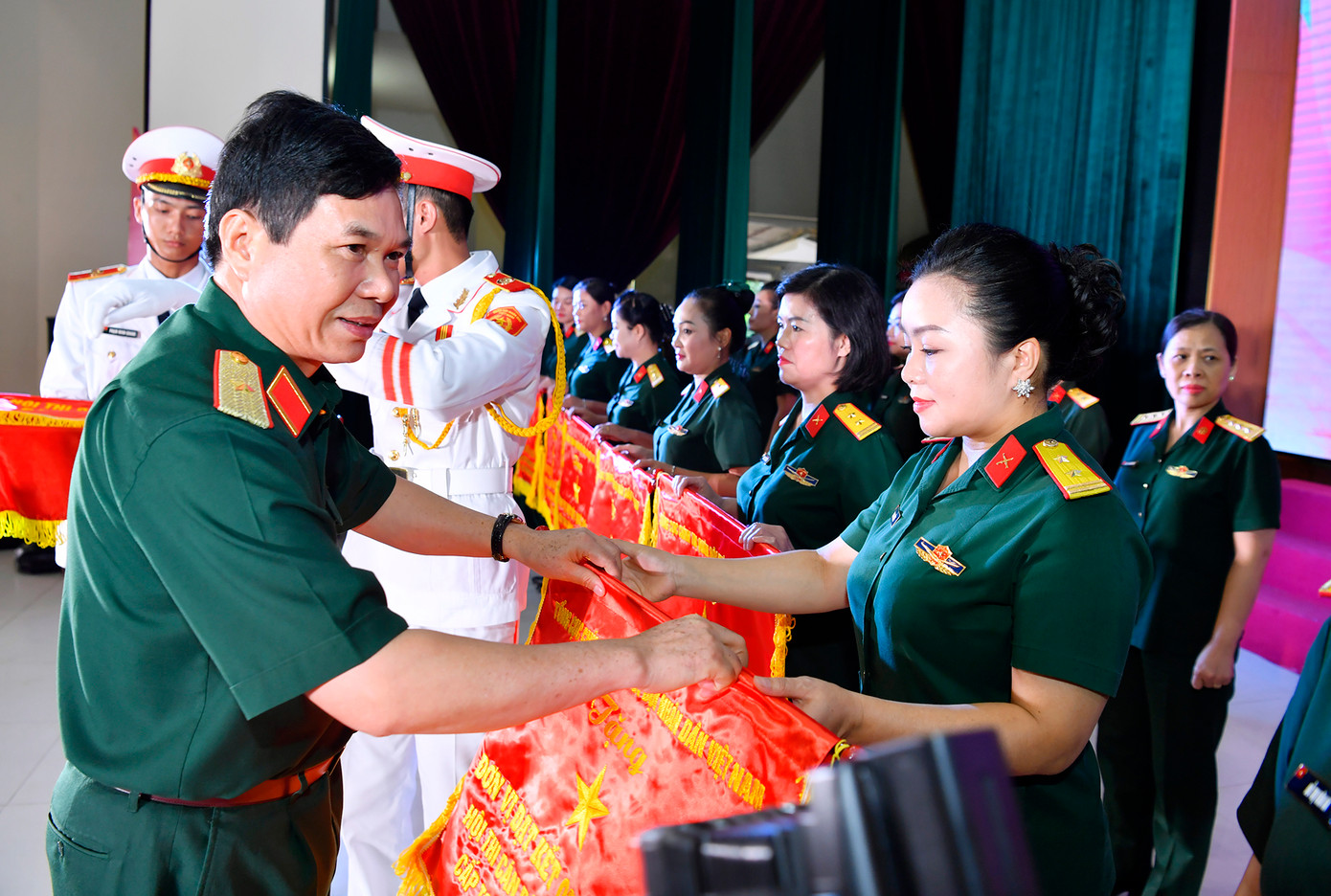 Thiếu tướng Bùi Công Chức - Phó Chính ủy Quân khu 3 và Đại tá Phùng Thị Phú -Trưởng ban Phụ nữ Quân đội trao Cờ của Tổng cục Chính trị tặng các tập thể có kết quả xuất sắc trong hội thi.