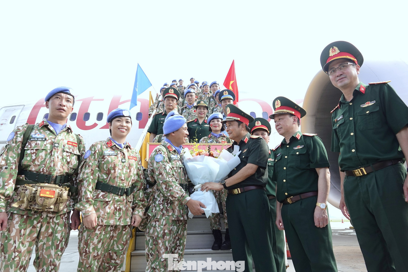 Thượng tướng Phùng Sĩ Tấn - Phó Tổng Tham mưu trưởng Quân đội nhân dân Việt Nam tặng hoa cho chỉ huy và các thành viên Đội Công binh số 2, tại chân cầu thang máy bay ở Sân bay quốc tế Nội Bài, sáng 8/8.