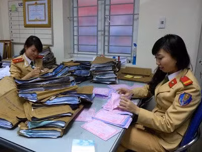 Trung sỹ Nguyễn Thị Kim Anh (bên phải) và Thiếu úy Lê Thị Hồng Duyên – đang làm nhiệm tại Tổ xử lý hồ sơ xe vi phạm tại Đội CSGT số 7