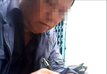 Ông Hai đang viết giấy thỏa thuận cho cháu. Ảnh: TRẦN NGỌC