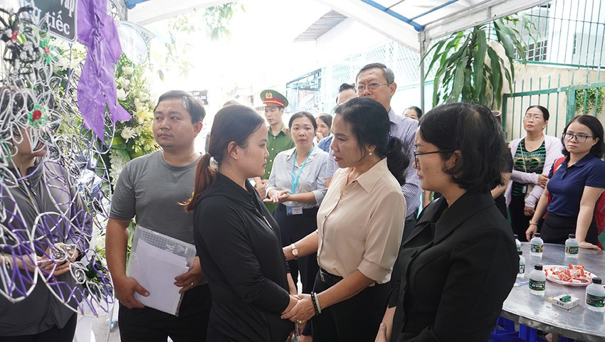 Phó Bí thư Thường trực Quận ủy quận Nguyễn Thị Thu Hoài (áo trắng) chia sẻ nỗi đau, mất mát với gia đình nạn nhân. Ảnh: NT