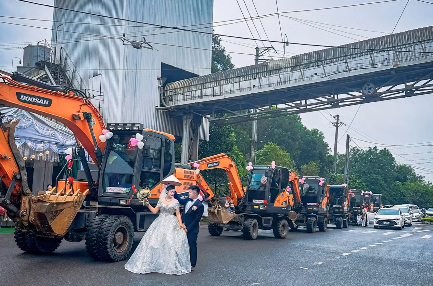 Cô dâu, chú rể chụp ảnh bên dàn máy xúc vào ngày cưới. Cô dâu, chú rể chụp ảnh bên dàn máy xúc vào ngày cưới.