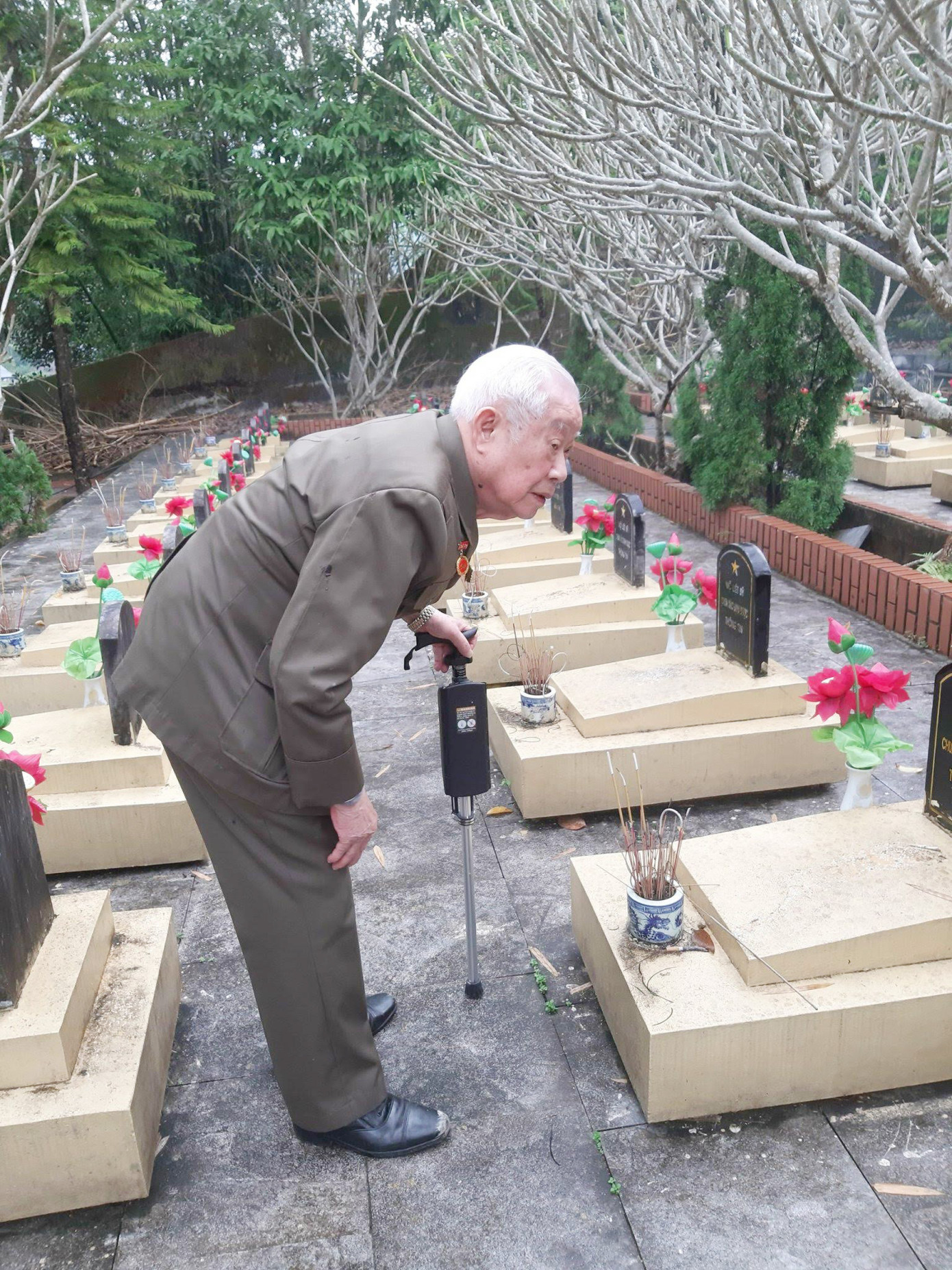 Cựu TNXP Nguyễn Tiến Năng thăm mộ các đồng đội tại Nghĩa trang liệt sĩ TNXP xã Chăn Nưa