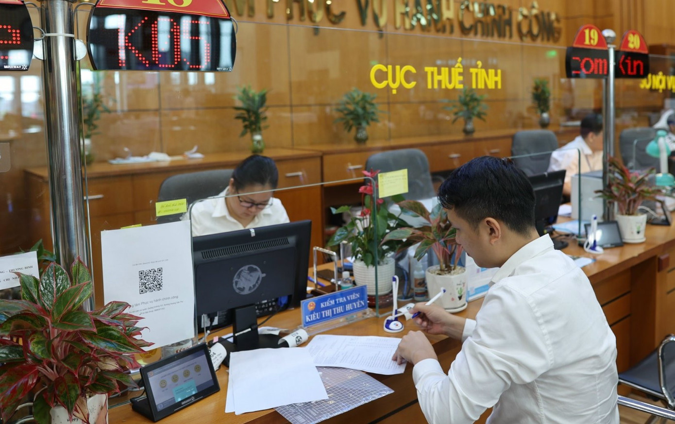 Người dân làm thủ tục nộp thuế tại cơ quan thuế. Ảnh: Như Ý. Người dân làm thủ tục nộp thuế tại cơ quan thuế. Ảnh: Như Ý.