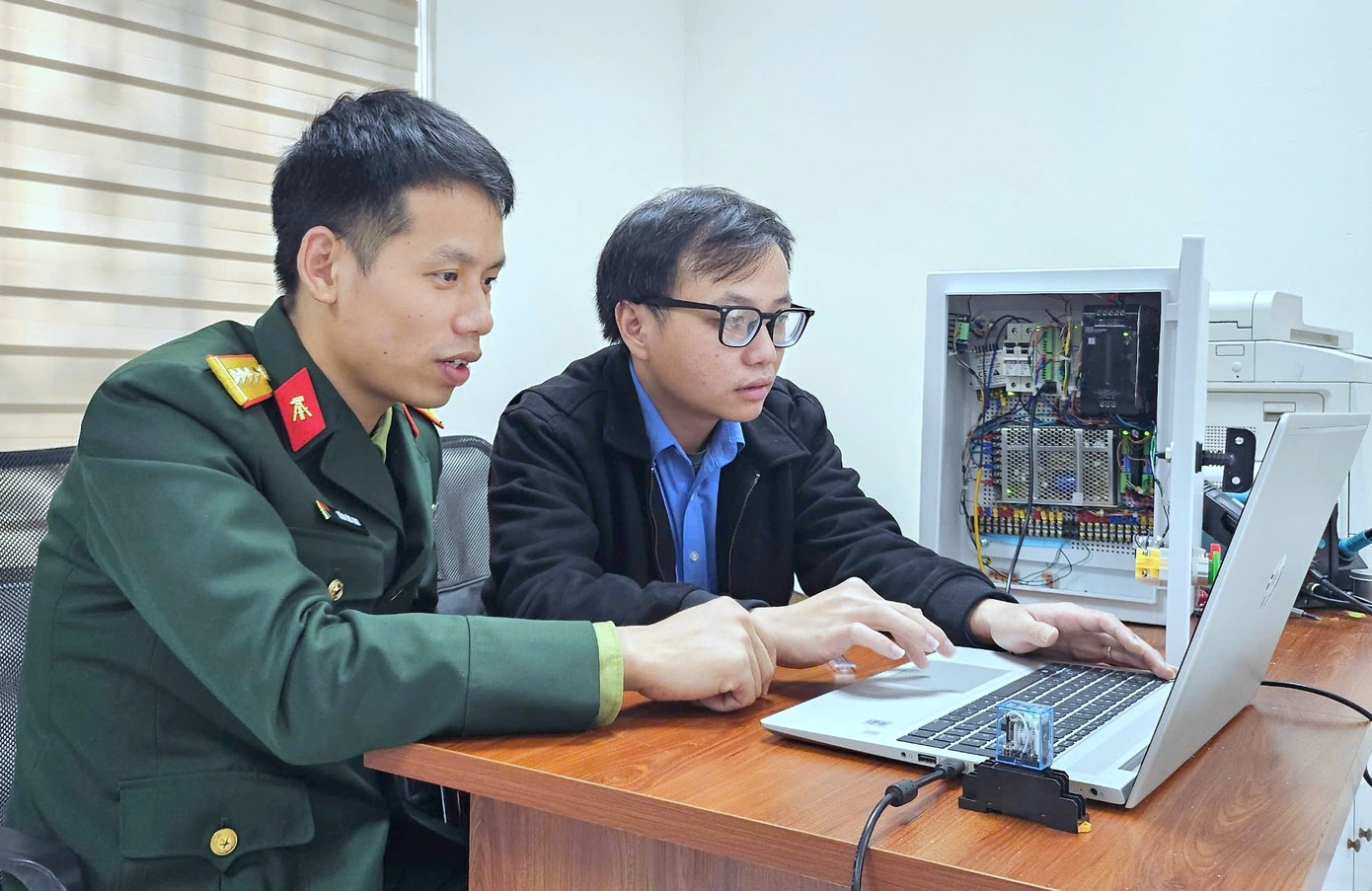 Đại úy Hoàng Đông Đông (bên phải) cùng đồng đội lập trình điều khiển cho một sản phẩm mới. Đại úy Hoàng Đông Đông (bên phải) cùng đồng đội lập trình điều khiển cho một sản phẩm mới.