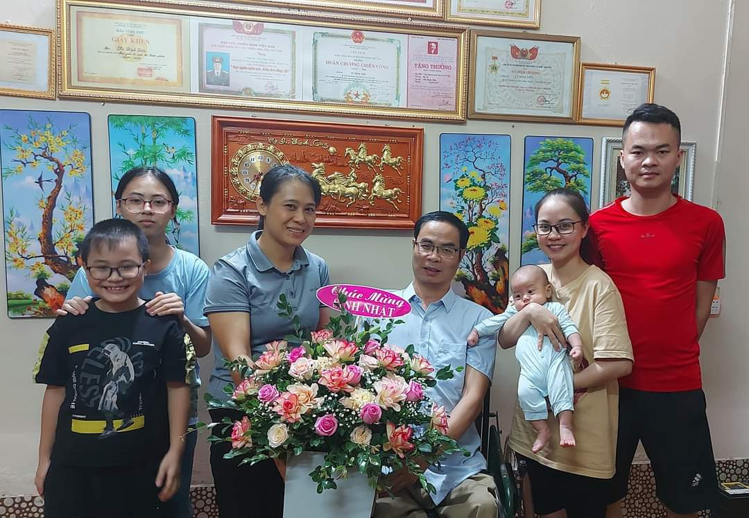 Thương binh Vũ Đình Tiến (thứ 4 trái sang) bên gia đình.