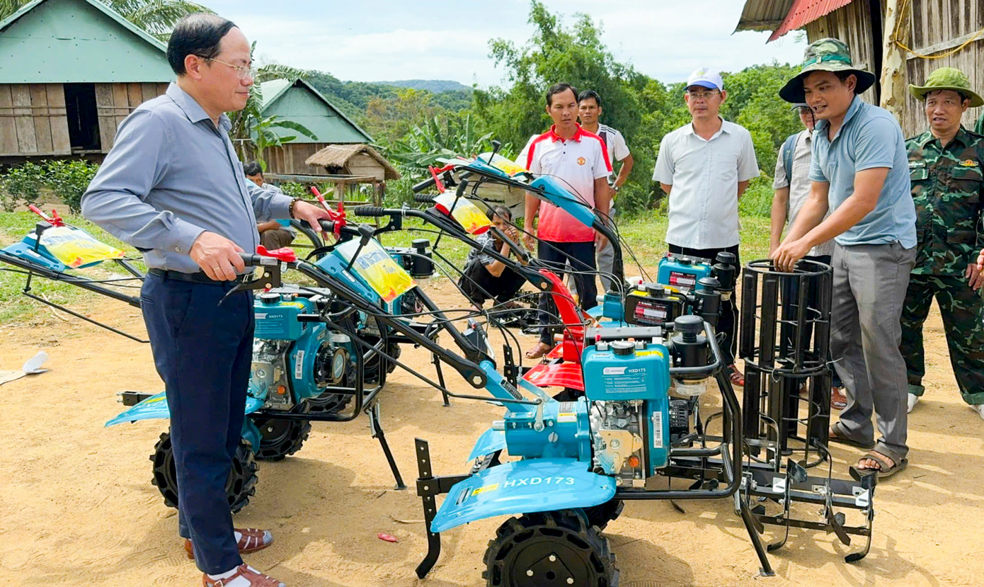 Chủ tịch UBND tỉnh Bình Định Phạm Anh Tuấn (bên trái) tặng máy cày cho bà con thôn O2. Ảnh: Vũ Việt Ân