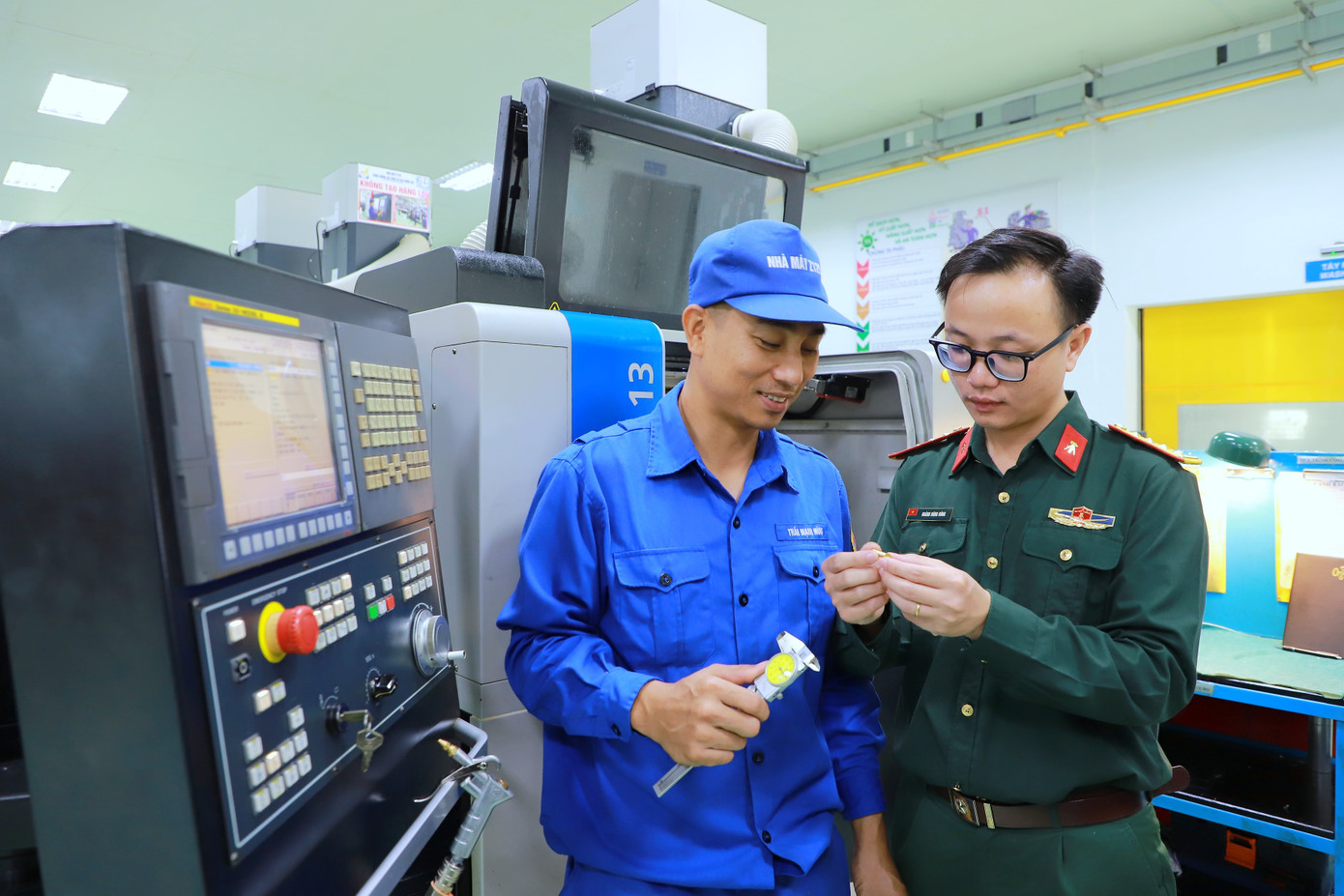 Đại úy Hoàng Đông Đông (bên phải) trao đổi với công nhân Phân xưởng Cơ khí chính xác của Nhà máy Z129 về một chi tiết kỹ thuật. Đại úy Hoàng Đông Đông (bên phải) trao đổi với công nhân Phân xưởng Cơ khí chính xác của Nhà máy Z129 về một chi tiết kỹ thuật.